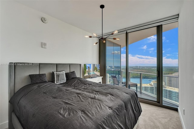 bedroom featuring light carpet, access to outside, a water view, and multiple windows