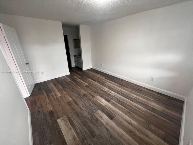 unfurnished bedroom featuring dark hardwood / wood-style flooring and a textured ceiling