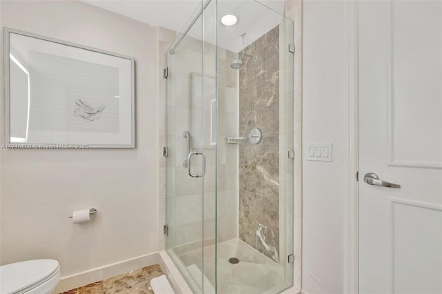 bathroom with tile patterned floors, toilet, and a shower with door