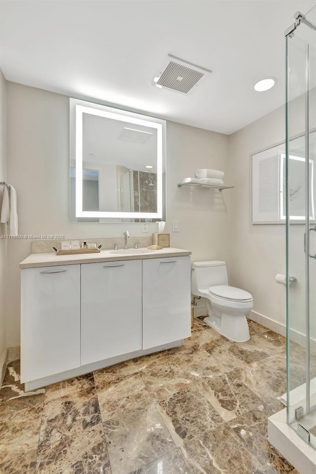 bathroom with vanity, toilet, and a shower with shower door