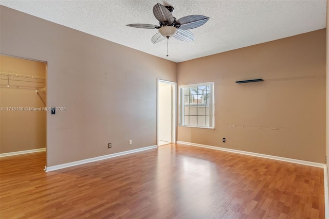 unfurnished room featuring ceiling fan, light hardwood / wood-style floors, and a textured ceiling