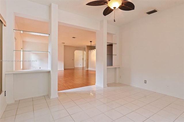 tiled spare room with ceiling fan