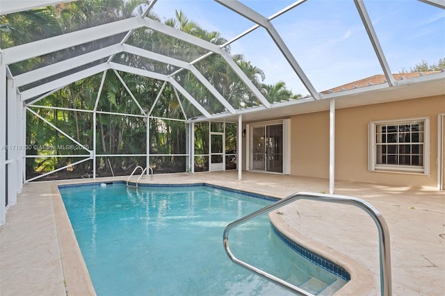 view of swimming pool featuring a patio area and a lanai