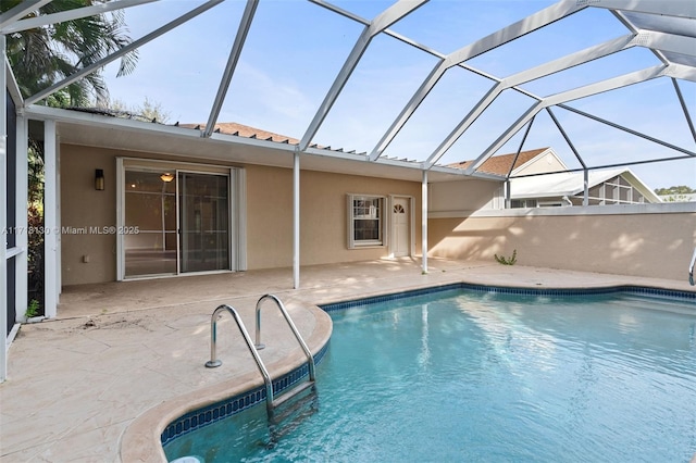 view of swimming pool with glass enclosure and a patio area