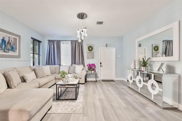 living room featuring an inviting chandelier and light hardwood / wood-style flooring