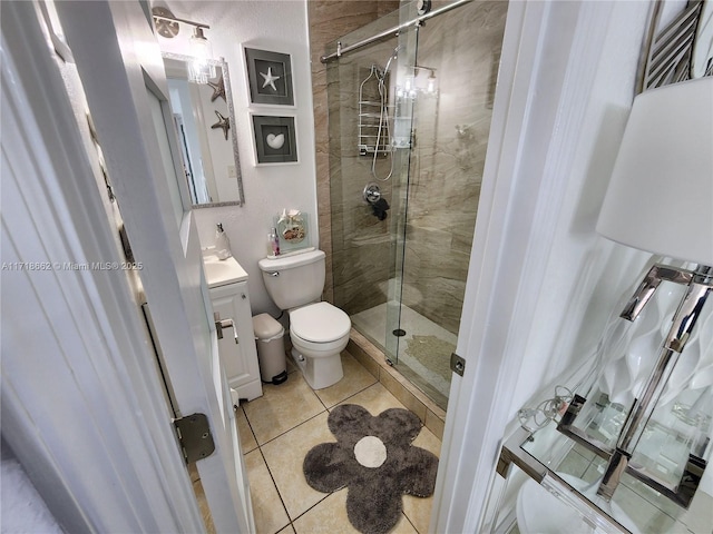 bathroom featuring tile patterned floors, toilet, vanity, and walk in shower