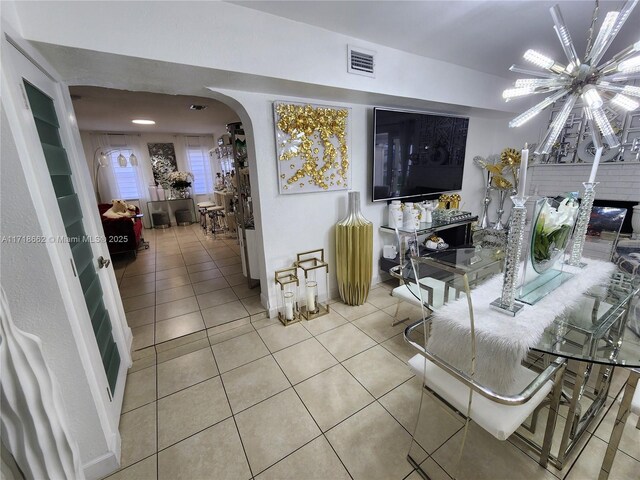 tiled living room with a notable chandelier