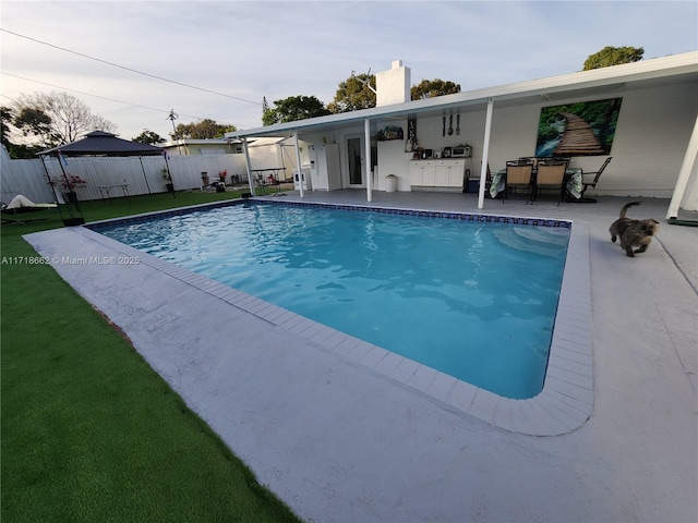 view of pool with a patio area and a lawn