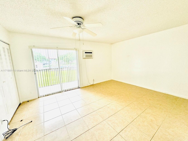 empty room with a wall mounted air conditioner, light tile patterned floors, a textured ceiling, and ceiling fan