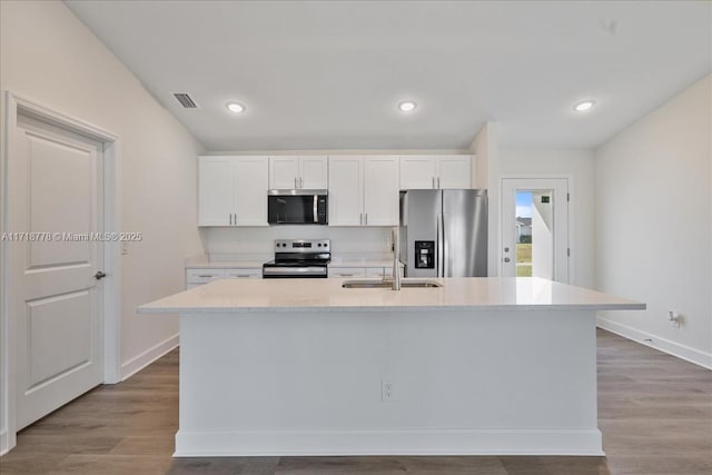 kitchen featuring a center island with sink, stainless steel appliances, white cabinets, and sink