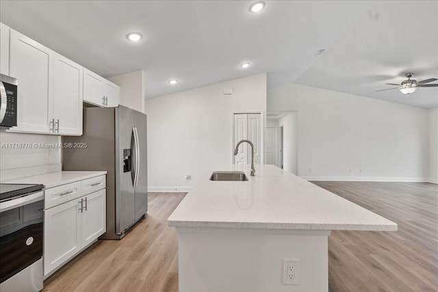 kitchen with ceiling fan, a center island with sink, sink, white cabinetry, and appliances with stainless steel finishes