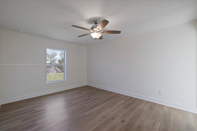 empty room with ceiling fan and dark hardwood / wood-style flooring