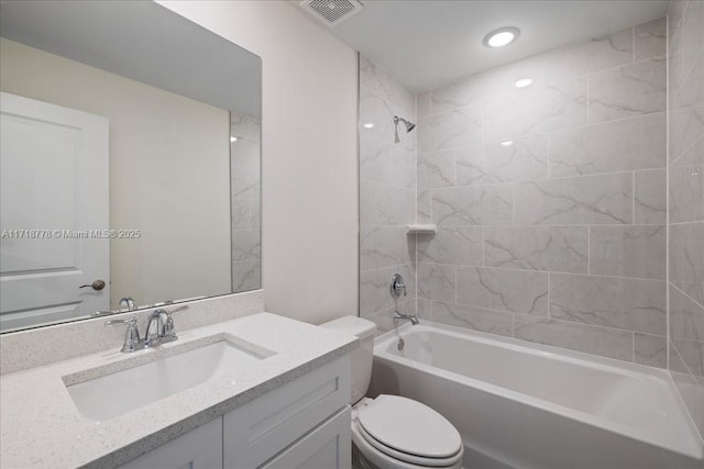 full bathroom featuring toilet, tiled shower / bath combo, and vanity