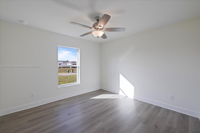 empty room with ceiling fan and dark hardwood / wood-style flooring