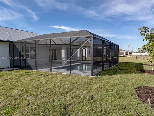 rear view of property featuring a lanai, a patio area, and a yard