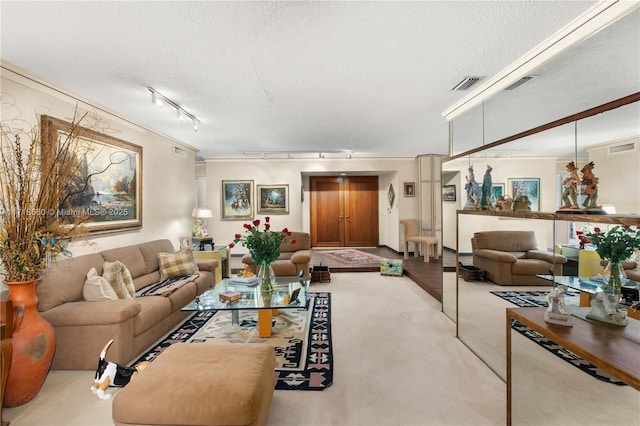 living room with rail lighting, ornamental molding, a textured ceiling, and light carpet