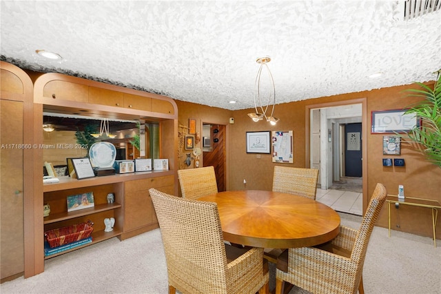 dining space with light colored carpet and a textured ceiling