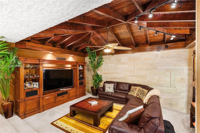 living room with vaulted ceiling with beams, wood walls, light colored carpet, track lighting, and wood ceiling