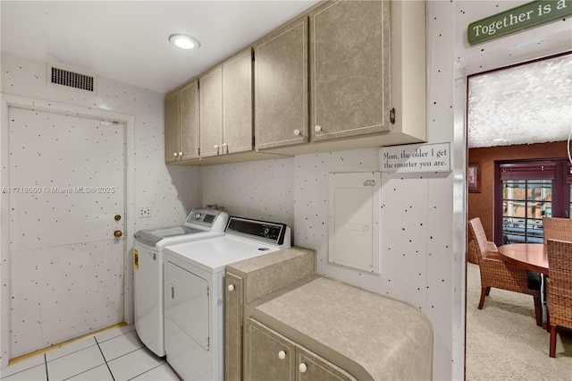 laundry room with cabinets, light tile patterned floors, and washing machine and dryer