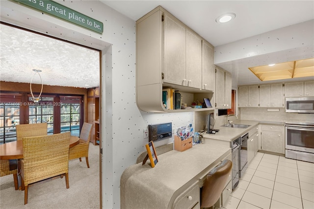 kitchen with sink, light tile patterned floors, stainless steel appliances, and decorative light fixtures