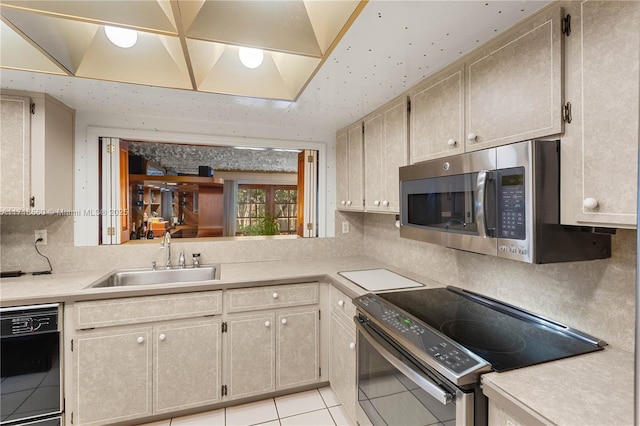 kitchen featuring appliances with stainless steel finishes, tasteful backsplash, light tile patterned floors, and sink