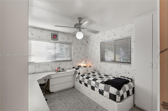 carpeted bedroom featuring multiple windows and ceiling fan