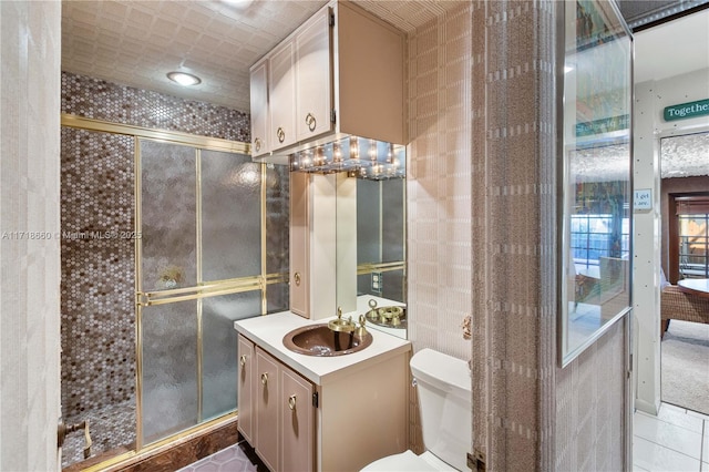 bathroom with tile patterned flooring, vanity, an enclosed shower, and toilet