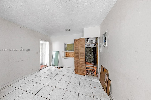 unfurnished living room with light tile patterned floors and a textured ceiling