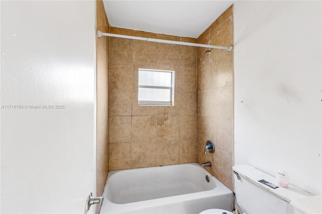 bathroom with tiled shower / bath combo and toilet