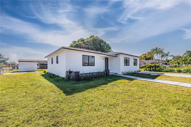 ranch-style home featuring central AC unit and a front yard