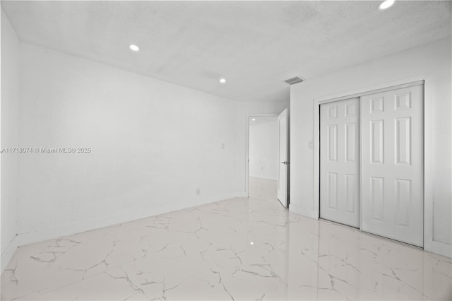 unfurnished bedroom with a closet and a textured ceiling