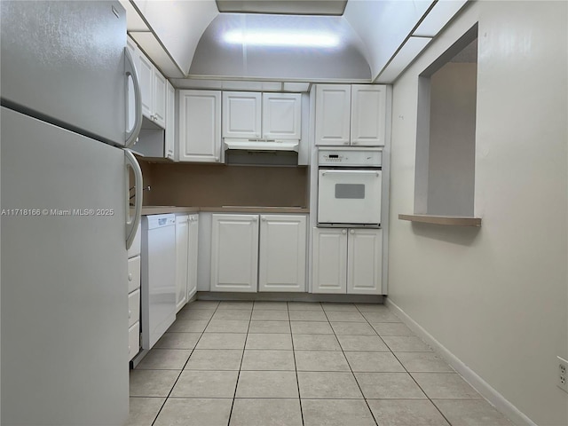 kitchen with white cabinets, light tile patterned floors, and white appliances