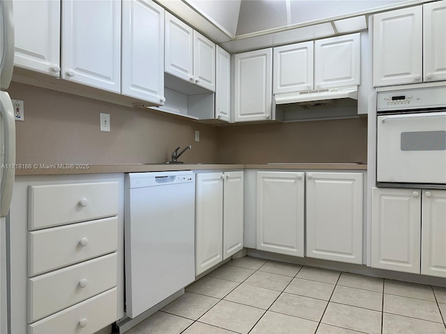 kitchen featuring white cabinetry, sink, light tile patterned floors, and white appliances