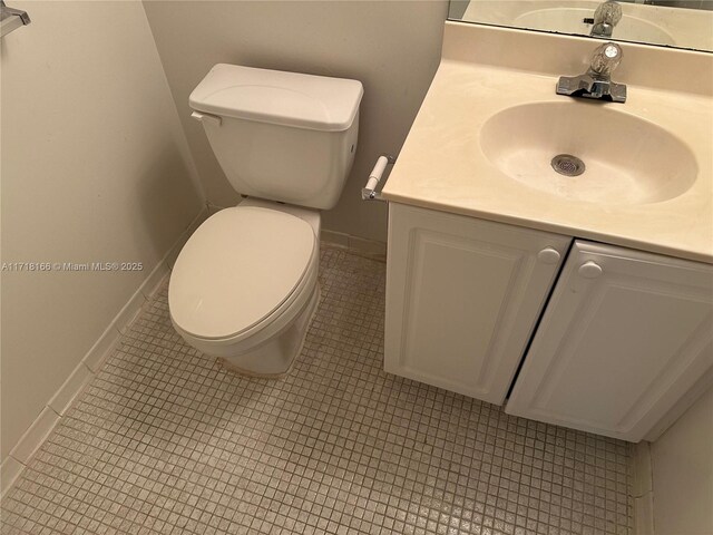 bathroom with tile patterned flooring, vanity, and toilet