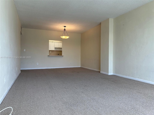 empty room with carpet floors and a textured ceiling