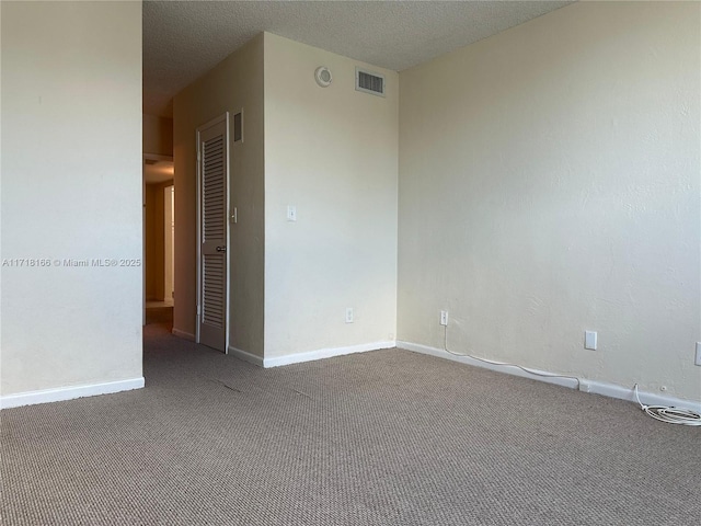 carpeted empty room with a textured ceiling