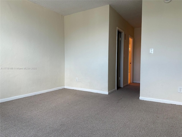 carpeted empty room featuring a textured ceiling