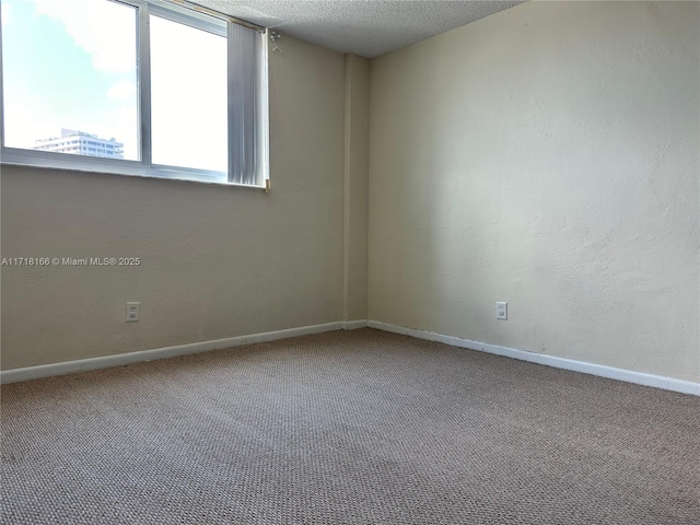 carpeted spare room with a textured ceiling