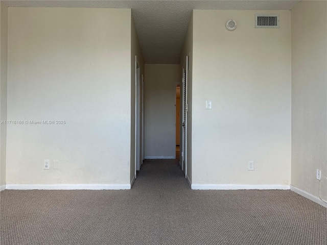 unfurnished room with dark carpet