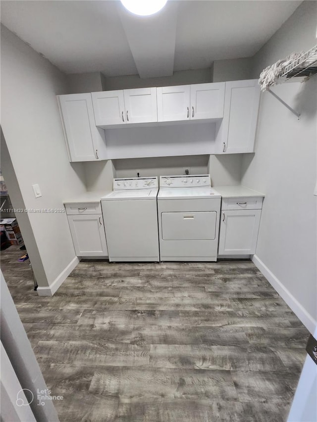 clothes washing area with dark hardwood / wood-style flooring, washer and clothes dryer, and cabinets