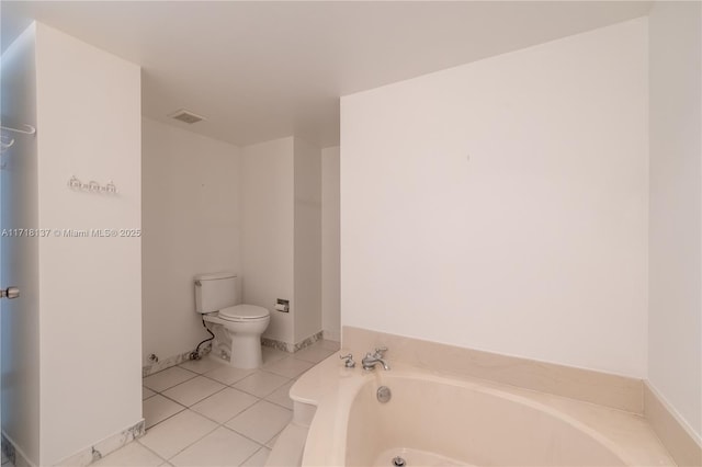 bathroom featuring a tub to relax in, tile patterned flooring, and toilet