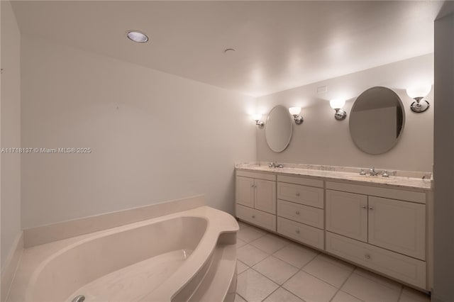 bathroom with a bathtub, vanity, and tile patterned flooring