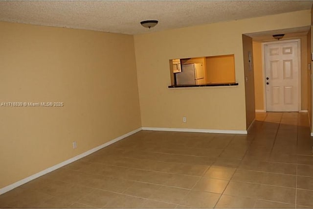 unfurnished room featuring tile patterned flooring and a textured ceiling