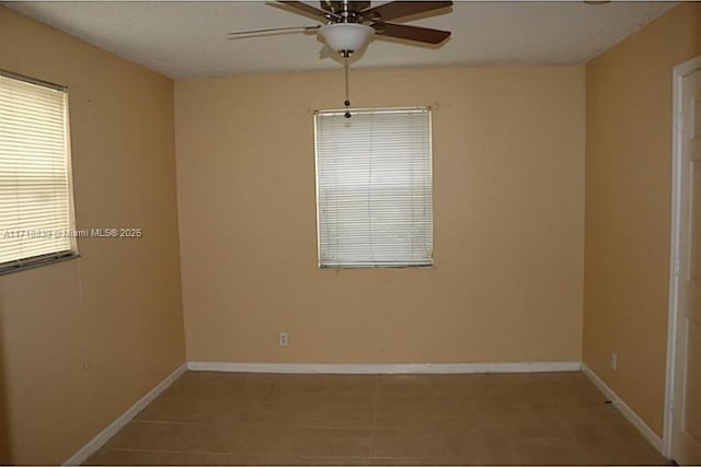 tiled spare room featuring ceiling fan