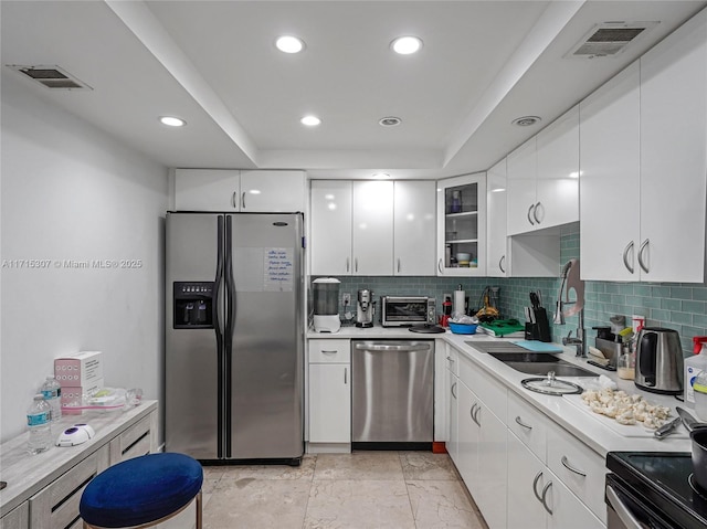 kitchen with visible vents, stainless steel appliances, white cabinets, and a sink