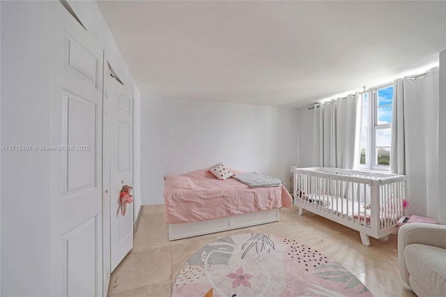 bedroom featuring light tile patterned floors and a closet