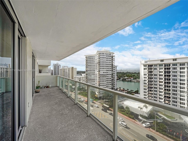 balcony featuring a water view and a city view