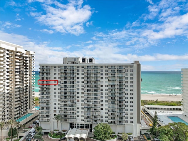 view of building exterior with a water view and a beach view