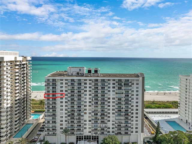 view of building exterior with a beach view and a water view