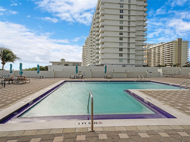 community pool featuring fence and a patio